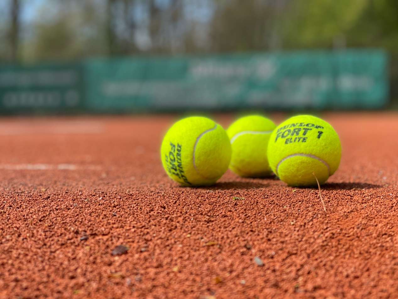 Drie tennisballen op het veld